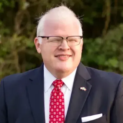 A man in a suit and tie is smiling for the camera.