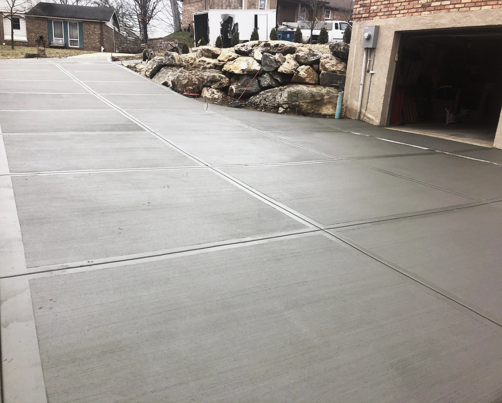 A concrete driveway is being built in front of a house.