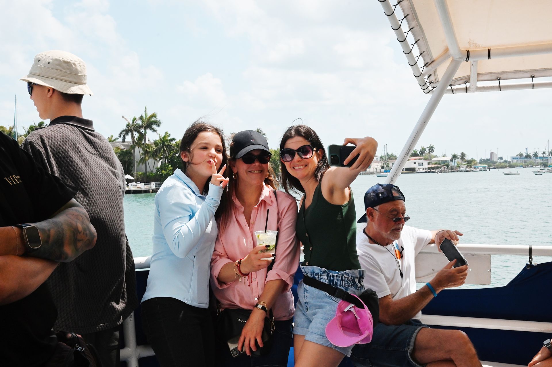 Family taking selfies with Star Island in the background on the Celebrity boat tour of Miami
