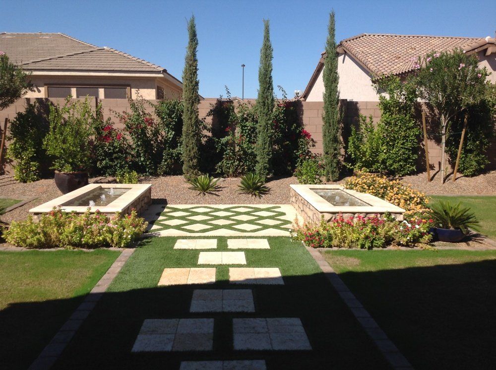 A lush green yard with a fountain in the middle