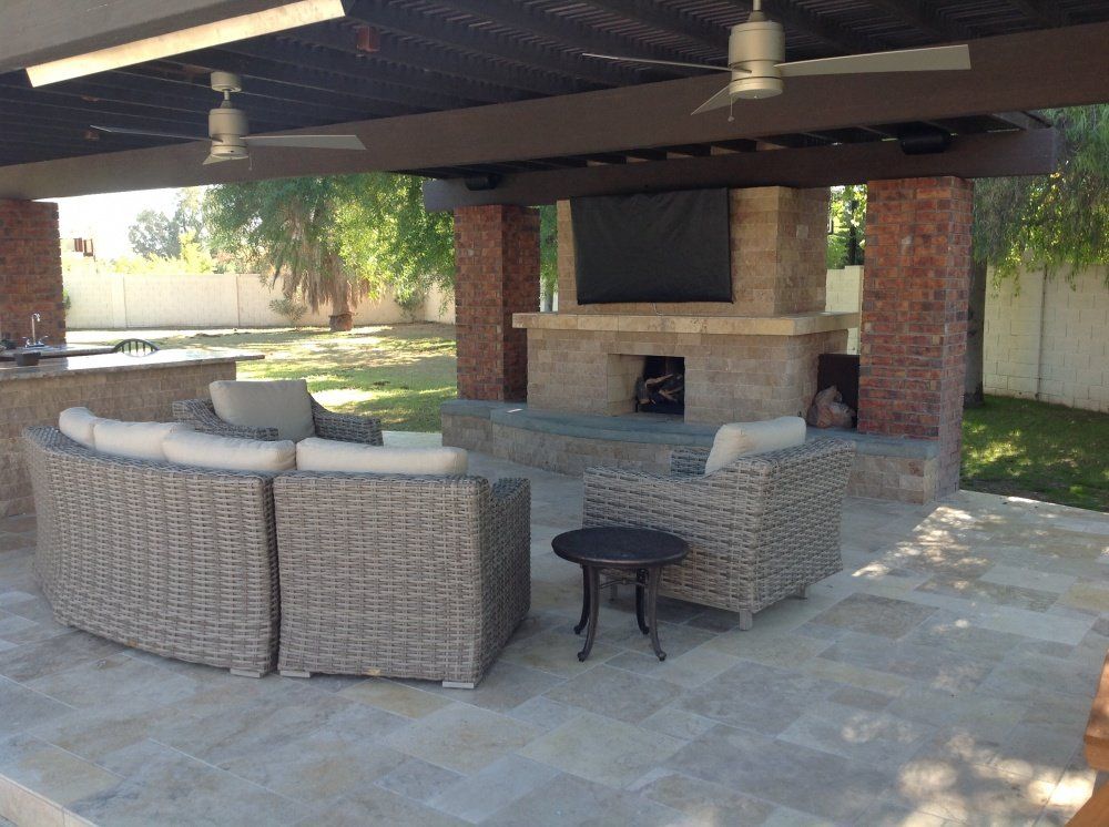 A patio with wicker furniture and a fireplace