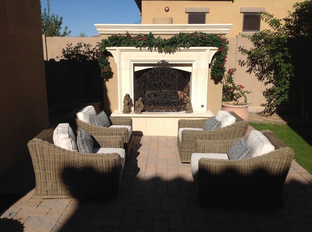 A patio with wicker furniture and a fireplace