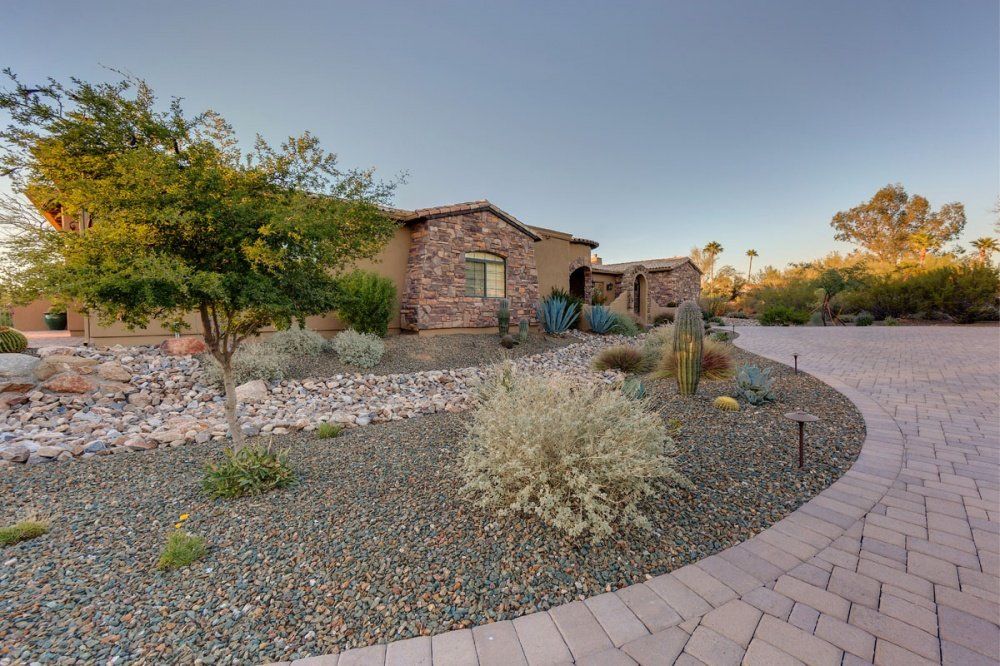 A brick driveway leading to a brick house