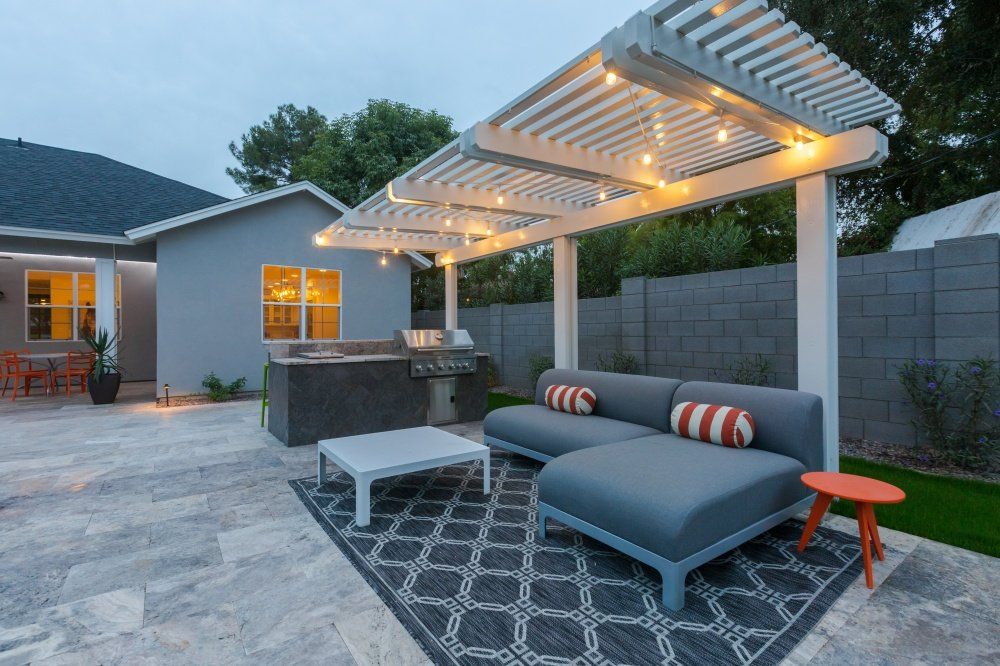 A patio with a couch and a table under a pergola.