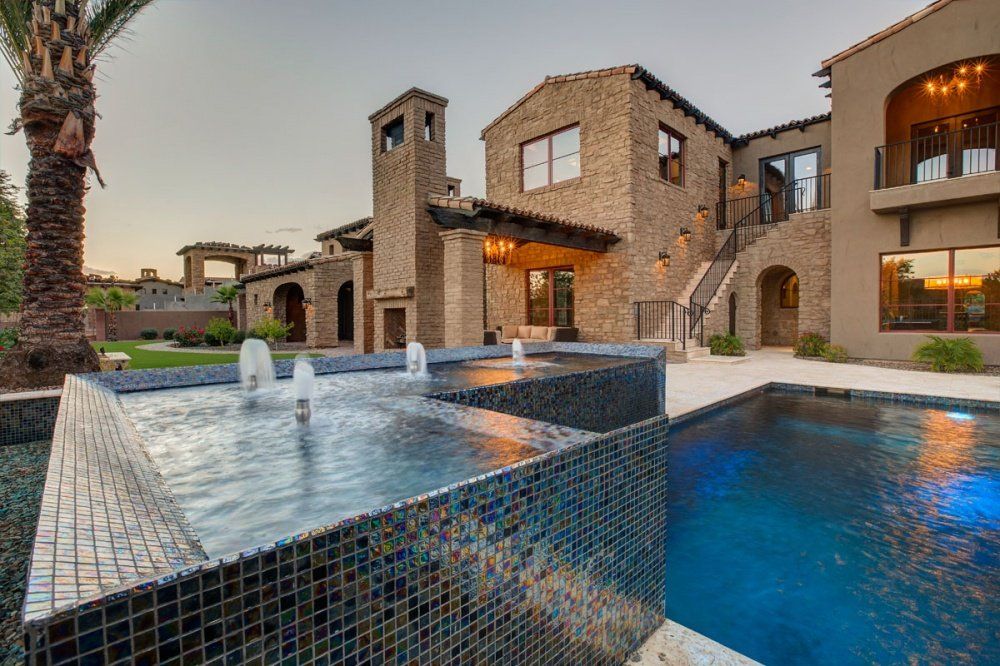 A large house with a swimming pool in front of it