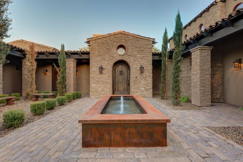 A large brick building with a fountain in front of it.