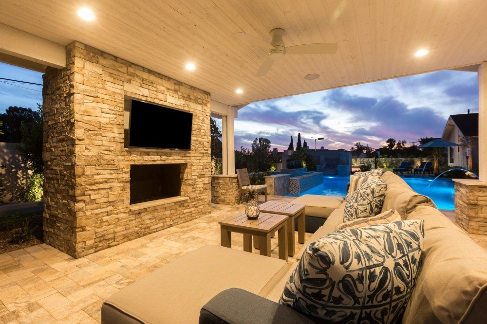 A living room with a couch and a television on the wall.