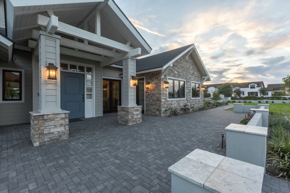 A large house with a brick driveway leading to it.