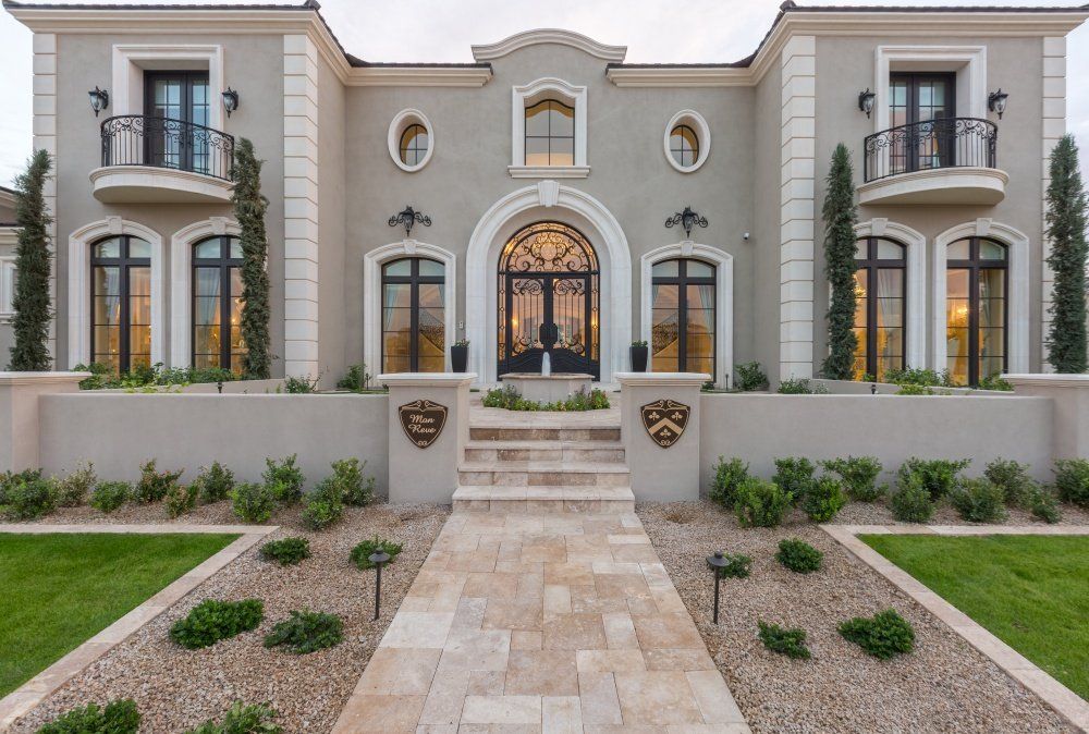 A large house with a walkway leading to the front door.