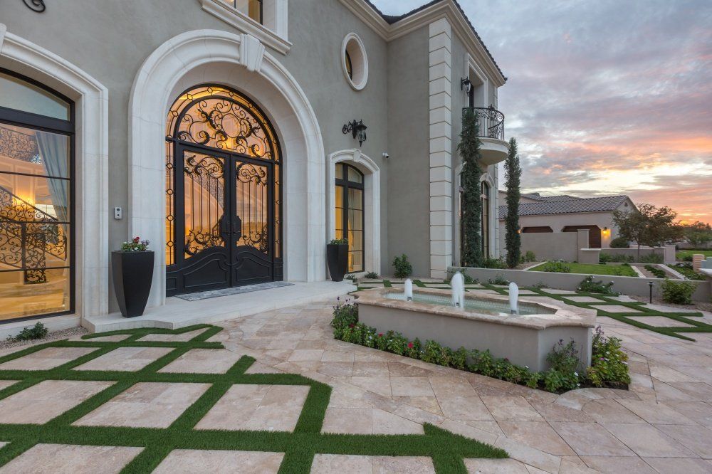 A large house with a fountain in front of it.