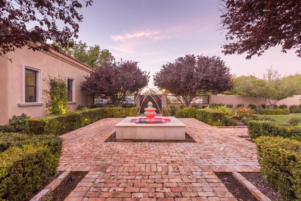 A brick walkway with a fountain in the middle
