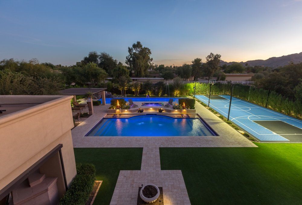 An aerial view of a large swimming pool and tennis court.