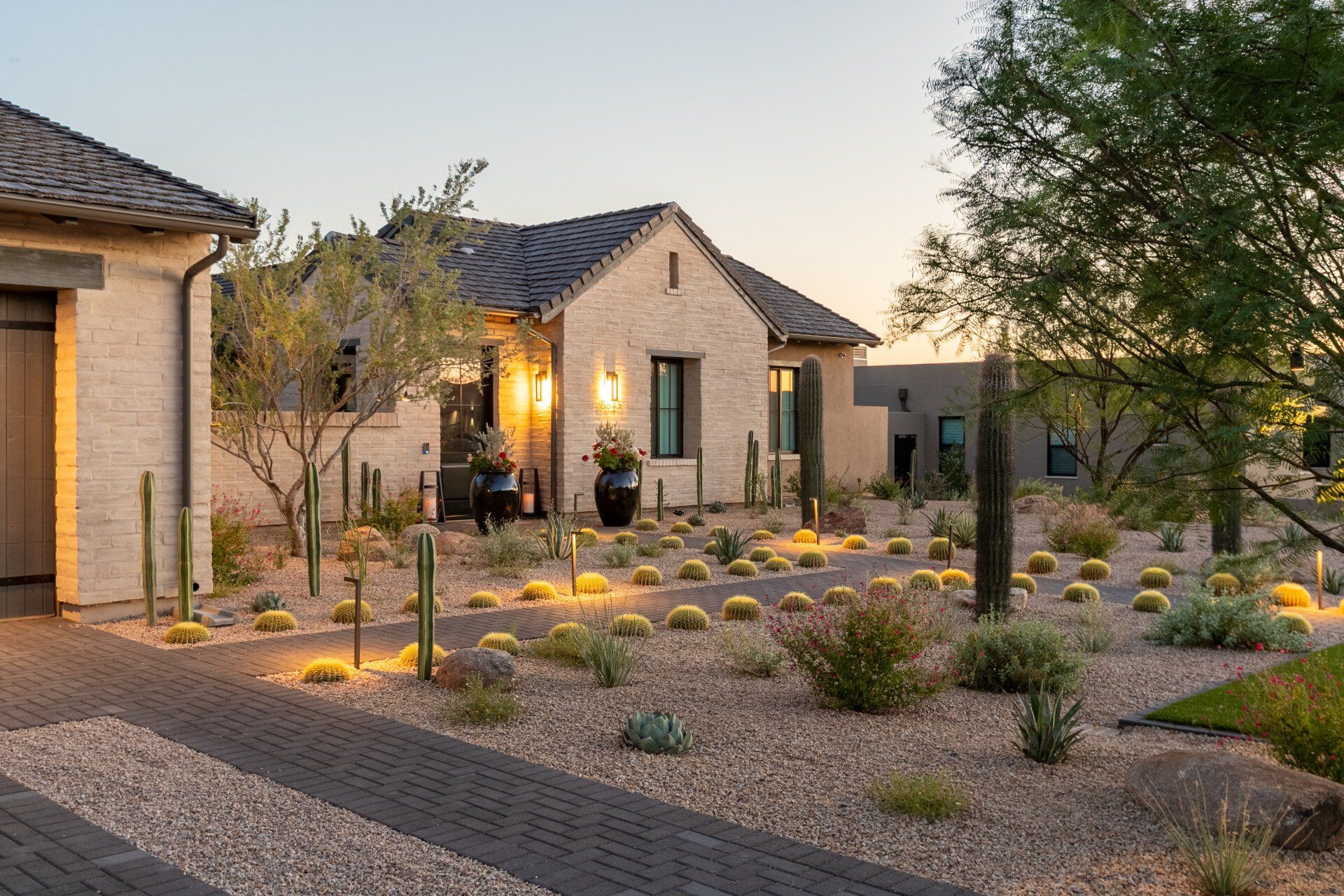 A large house with a lot of plants in front of it.