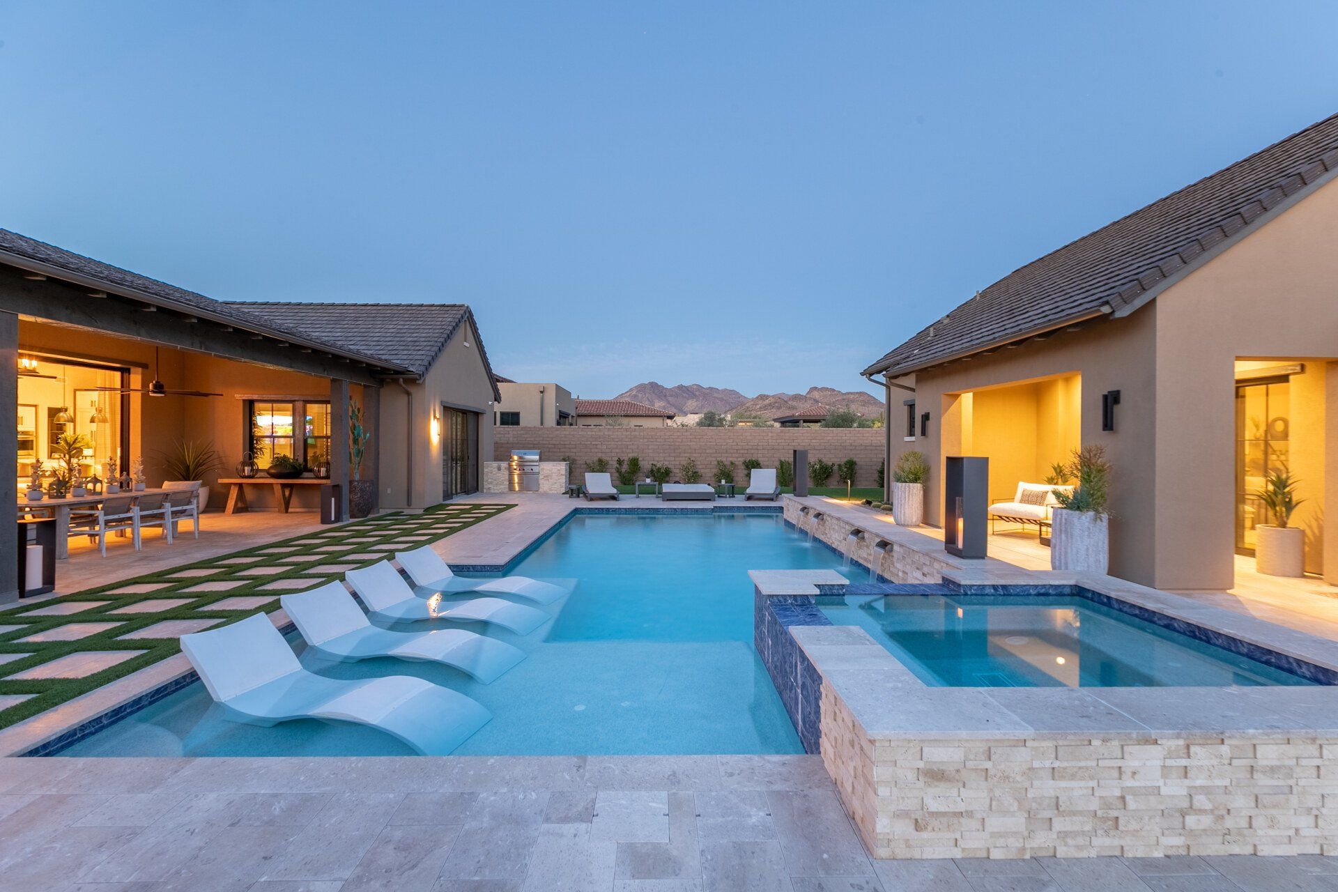 There is a large swimming pool in the middle of the backyard of a house.