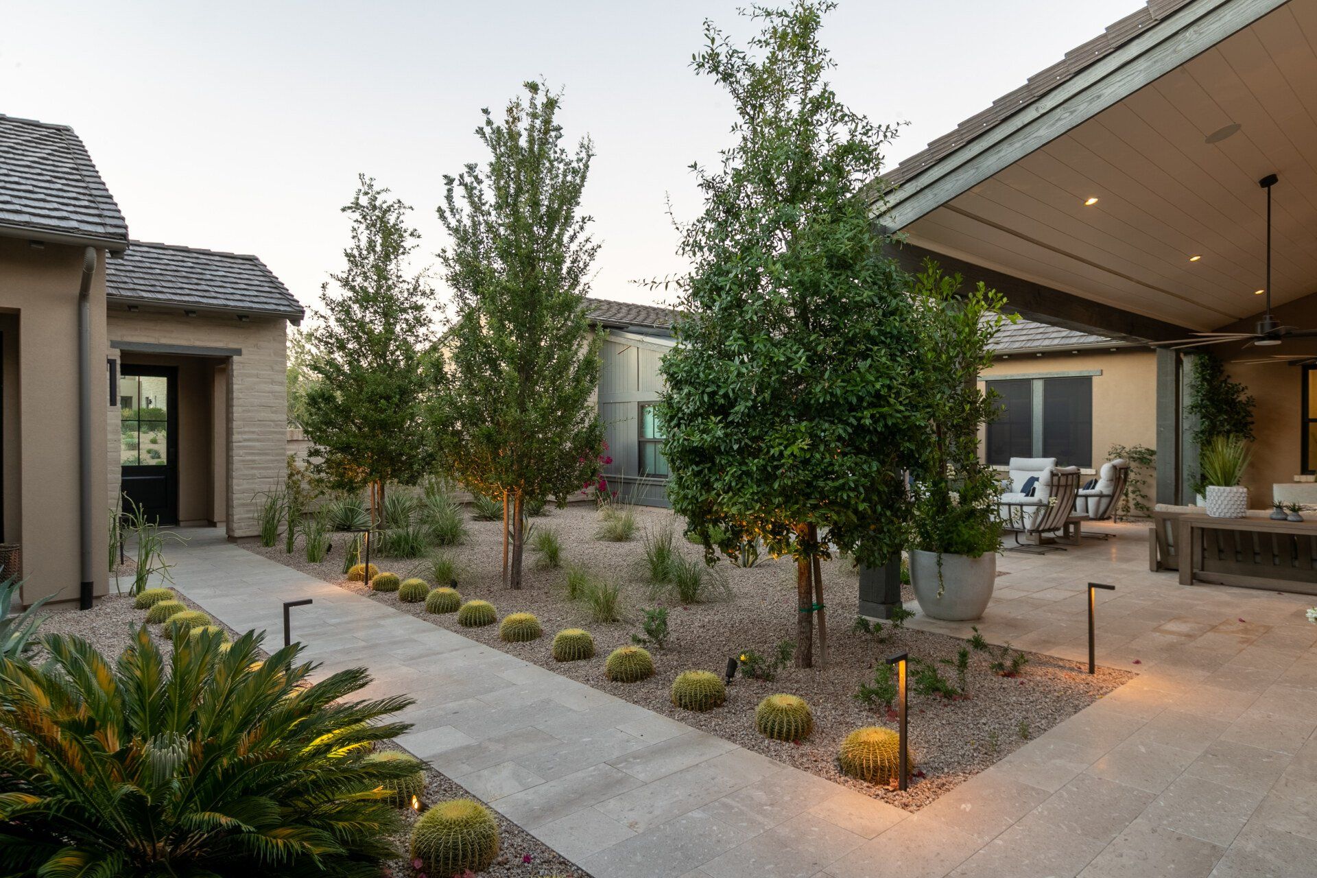 A house with a patio and trees in front of it.