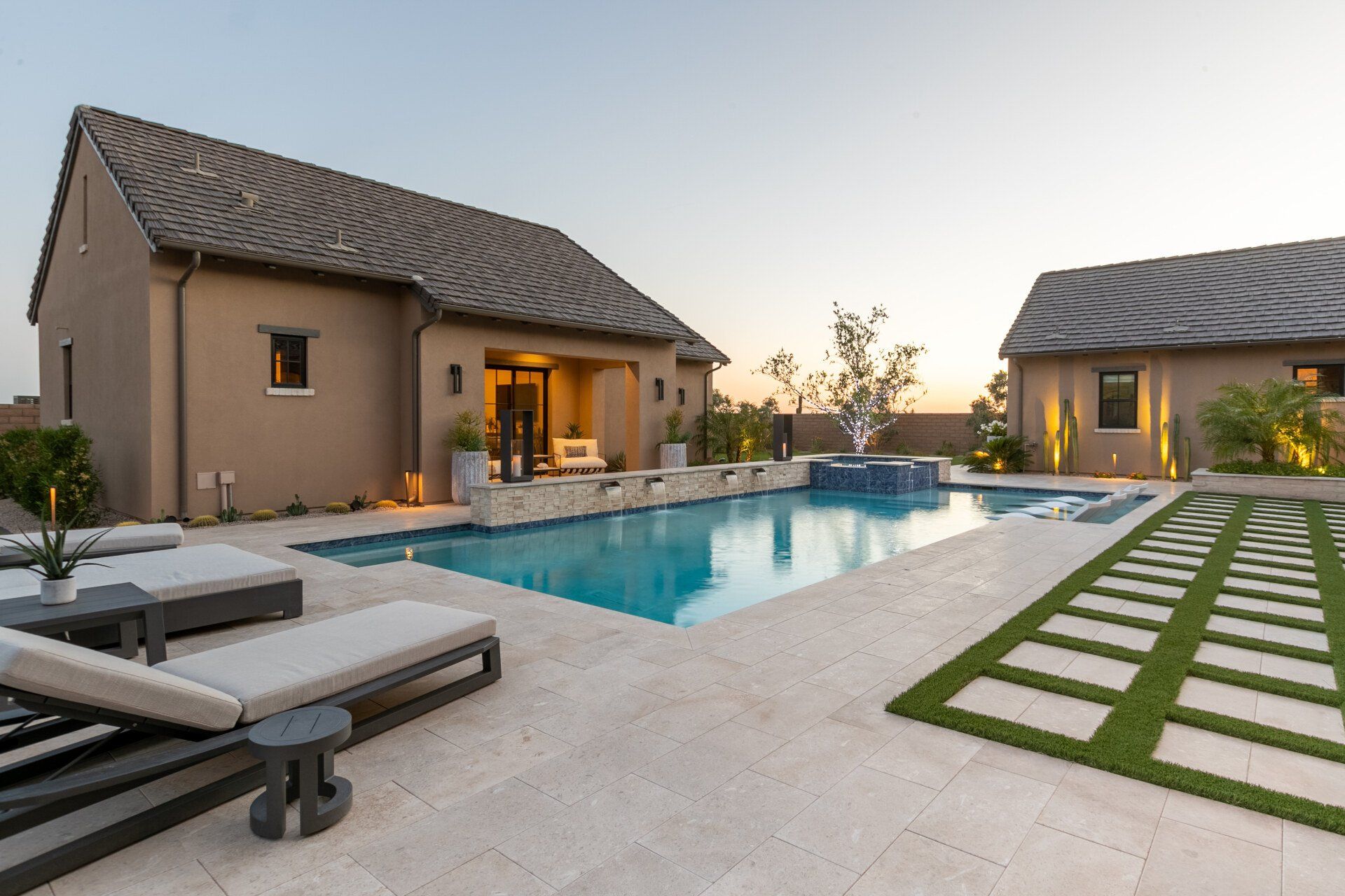 There is a large swimming pool in the backyard of a house.