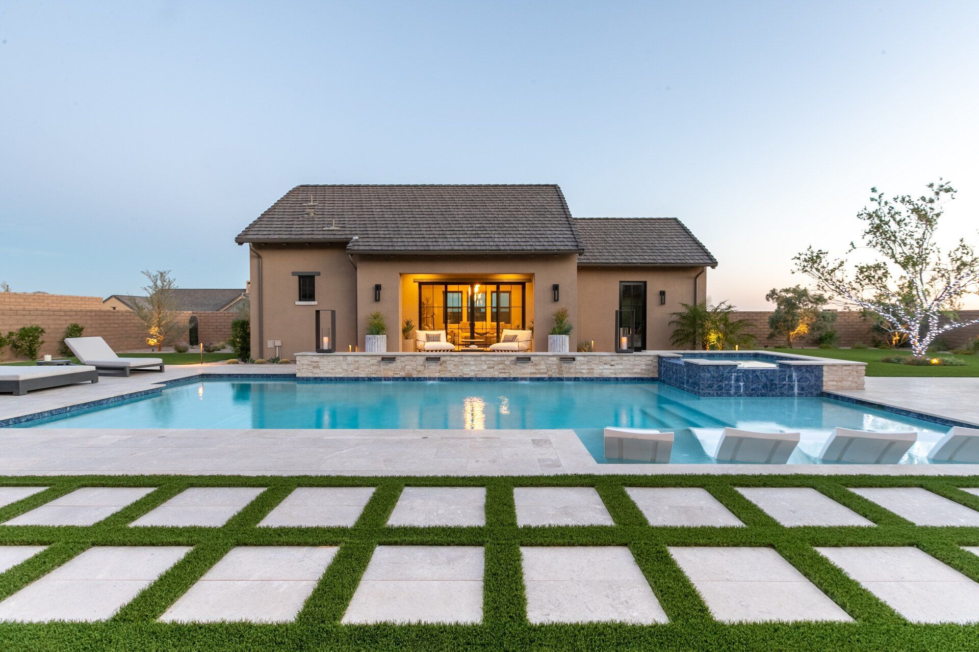 A house with a large swimming pool in front of it