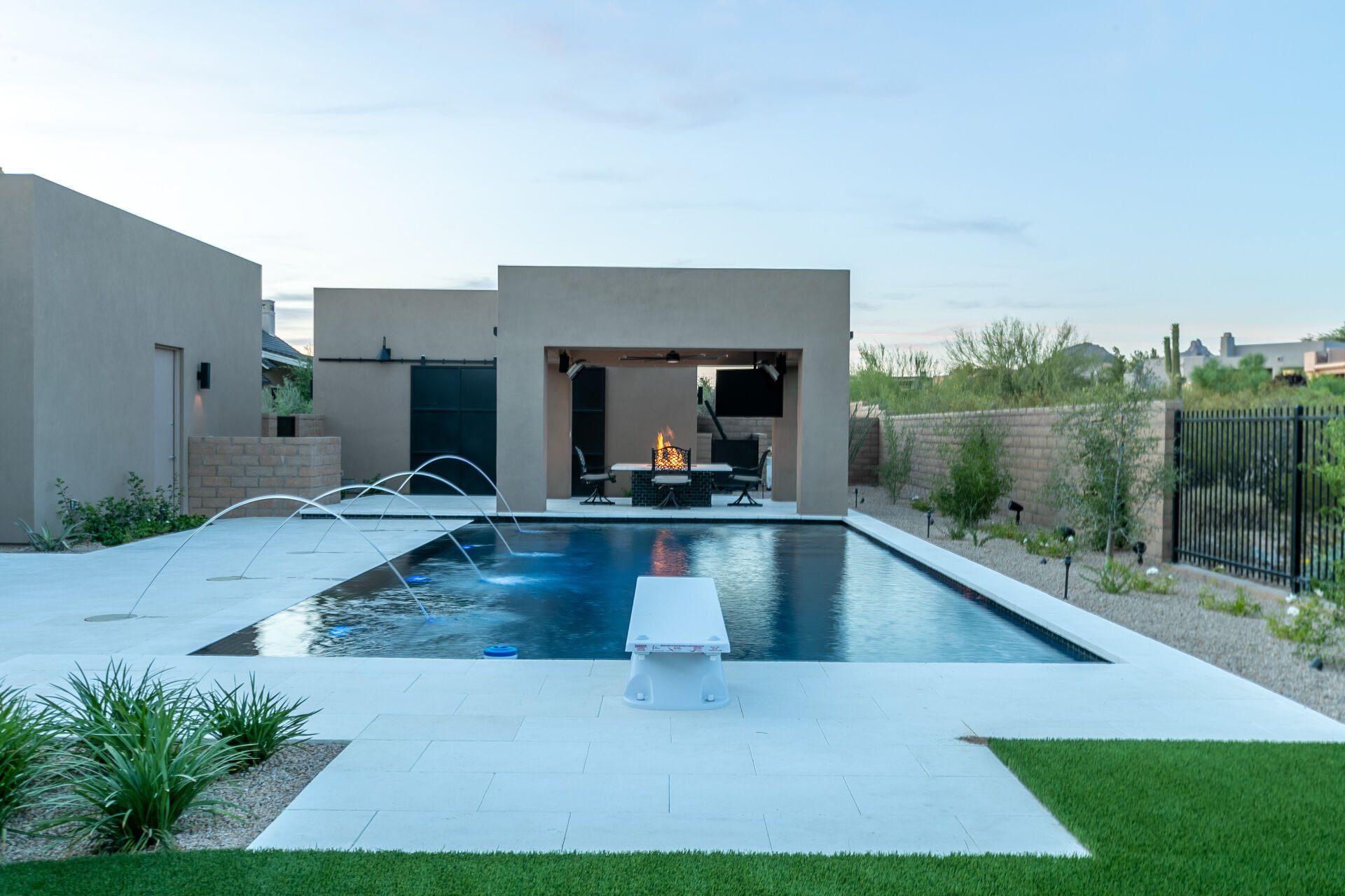 There is a large swimming pool in the backyard of a house.