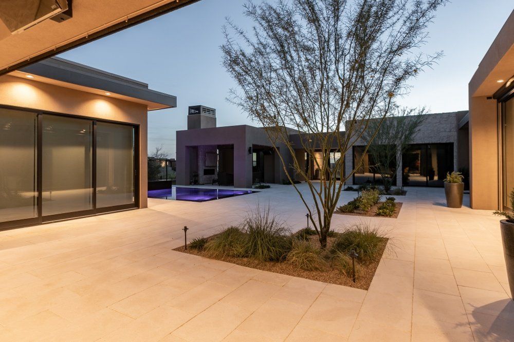 There is a tree in the middle of the courtyard between two buildings.