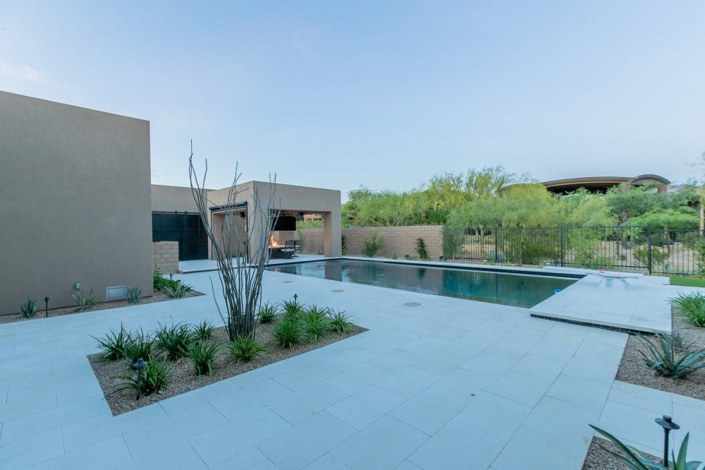 There is a large swimming pool in the backyard of a house.