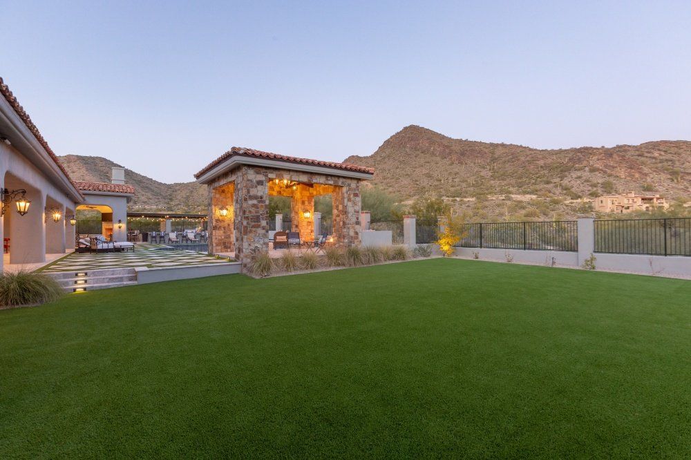 A large lawn in front of a house with mountains in the background.