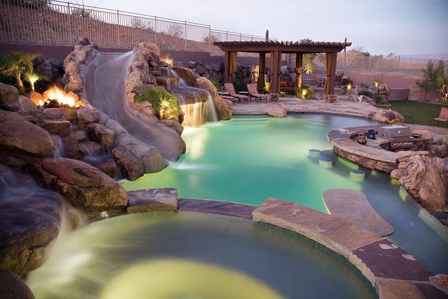 A large swimming pool with a waterfall in the middle of it