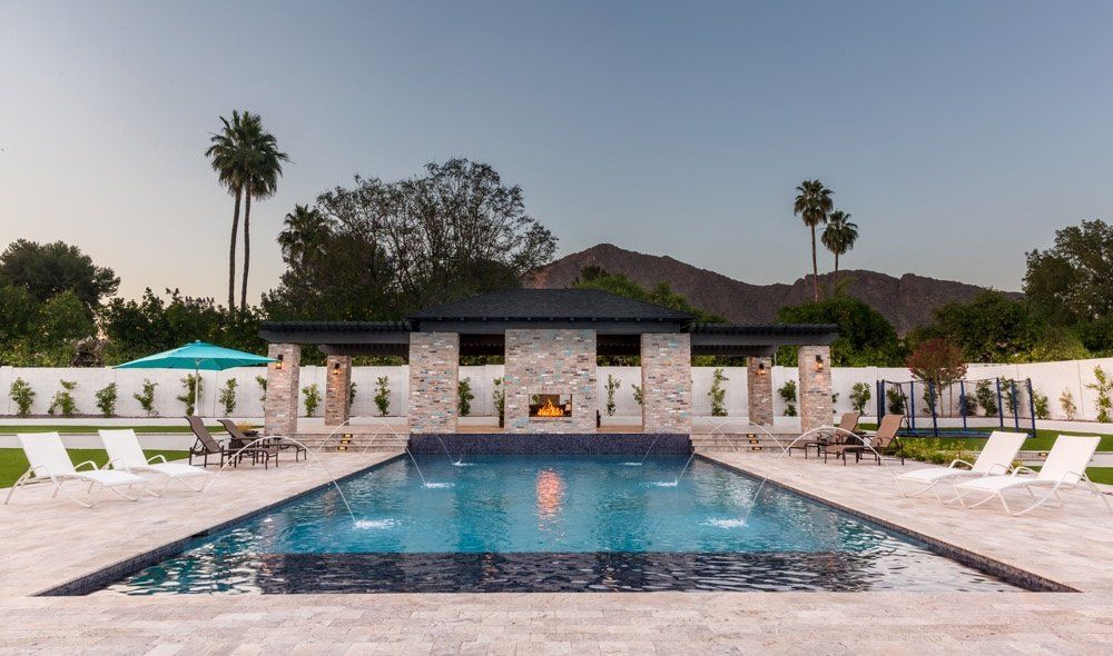 A large swimming pool with a fireplace in the middle