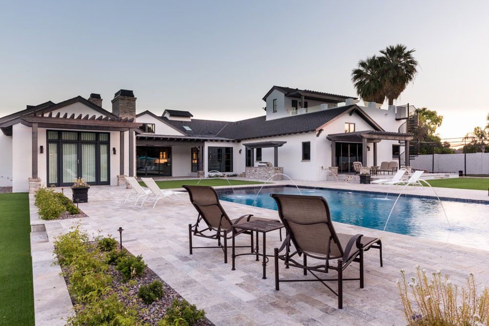A large white house with a large swimming pool in front of it.