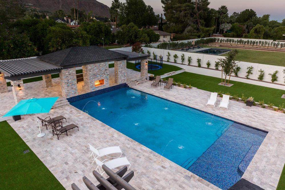 An aerial view of a large swimming pool surrounded by chairs and umbrellas.