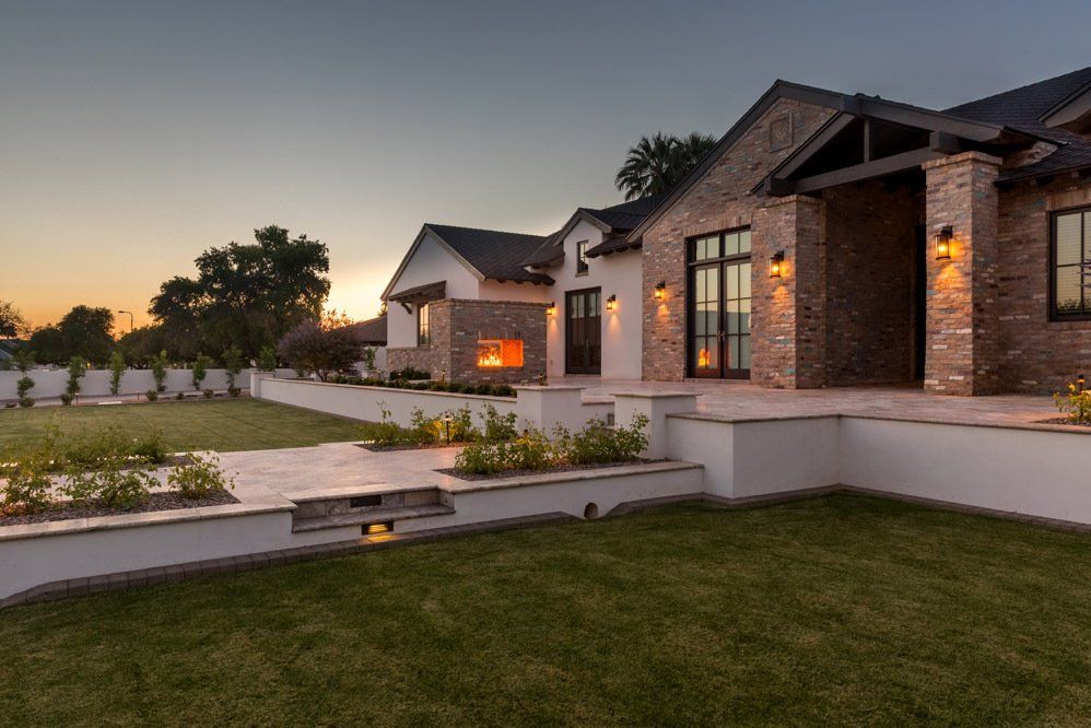 A large brick house with a fireplace in the backyard.