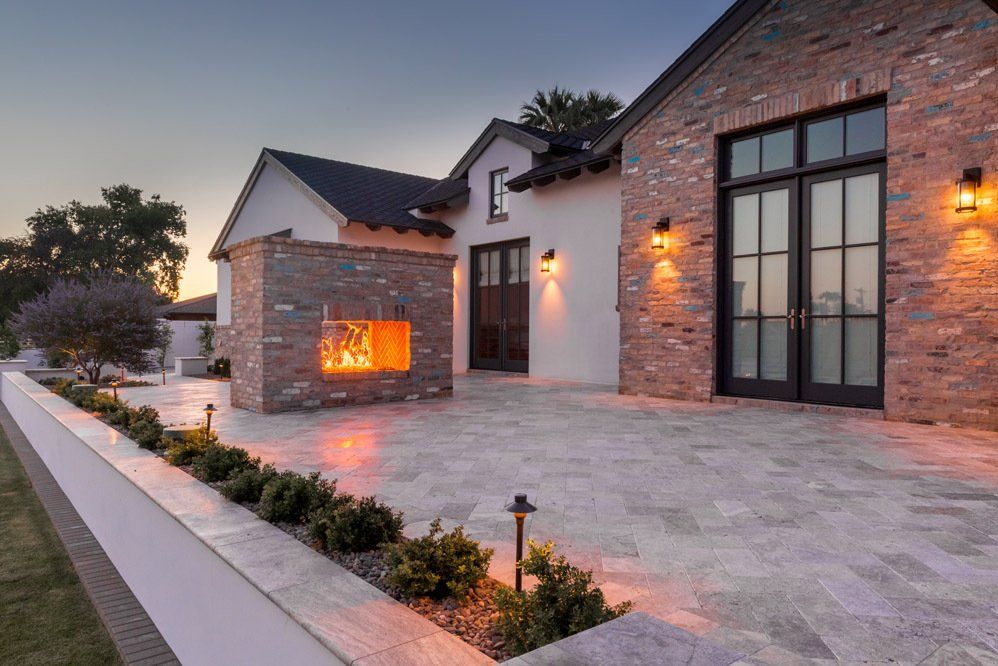 There is a fireplace in the backyard of a house.