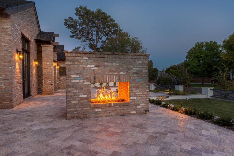 There is a fireplace in the middle of a brick wall.