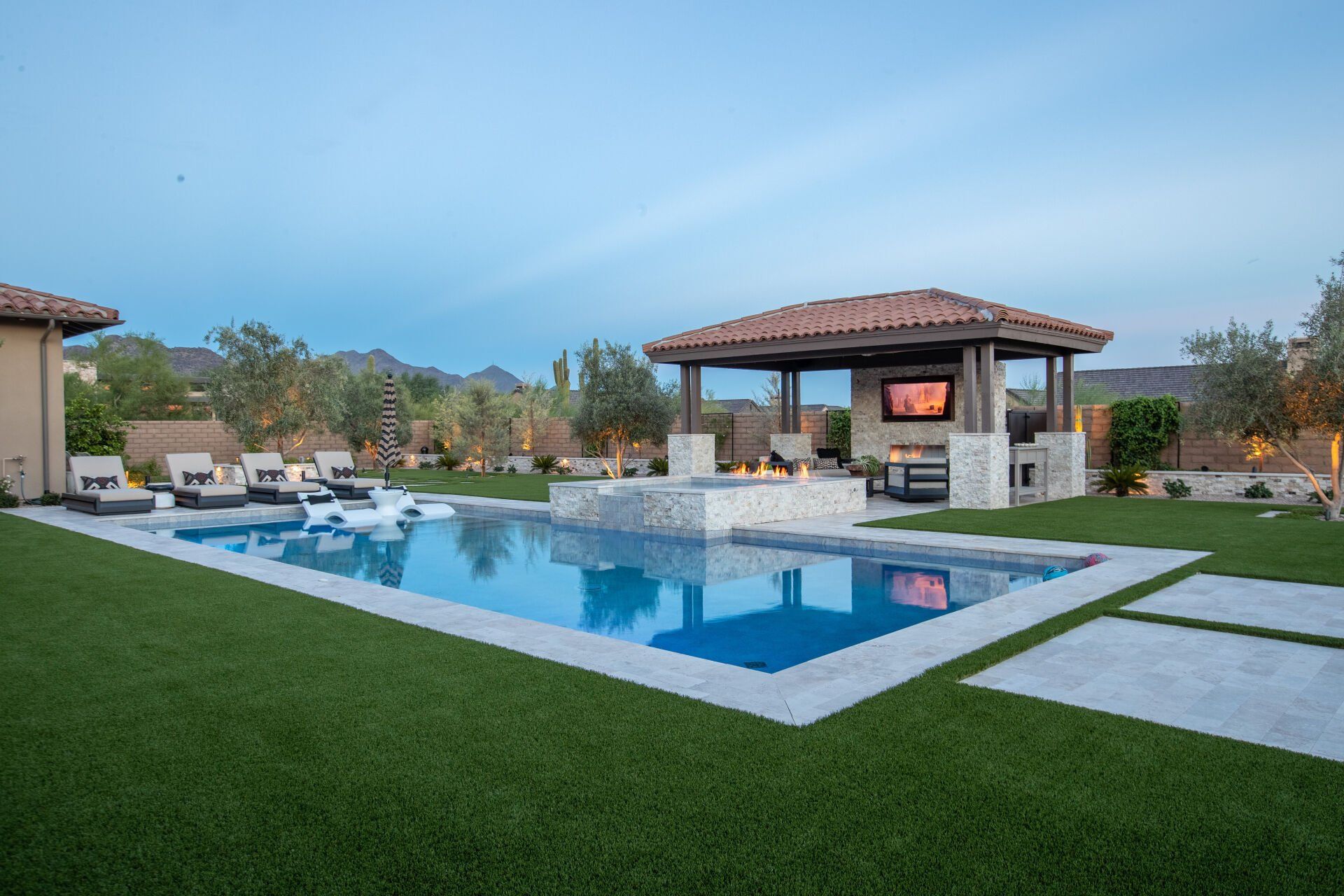 A large swimming pool with a gazebo in the backyard.