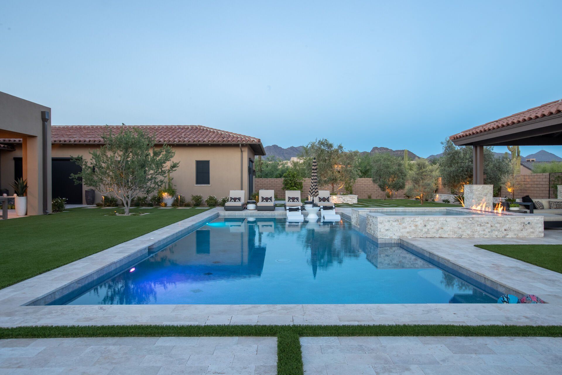 There is a large swimming pool in the backyard of a house.