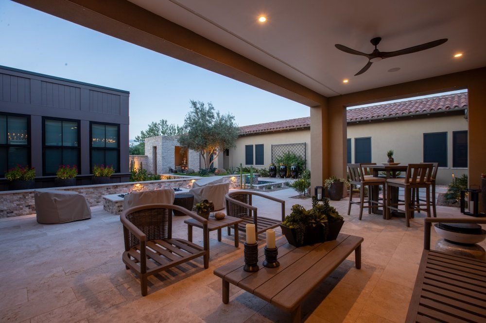A patio with a table and chairs and a ceiling fan