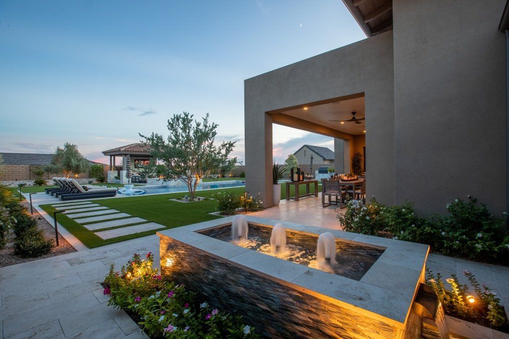 A large house with a pool and a fountain in the backyard.