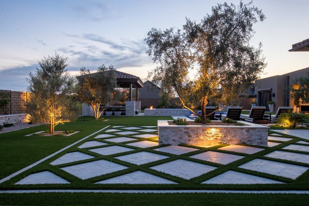 A large lawn with a tree in the middle of it.