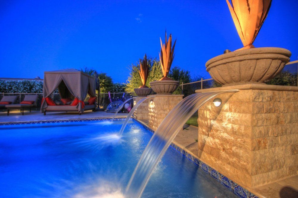 A swimming pool with a waterfall in the middle of it