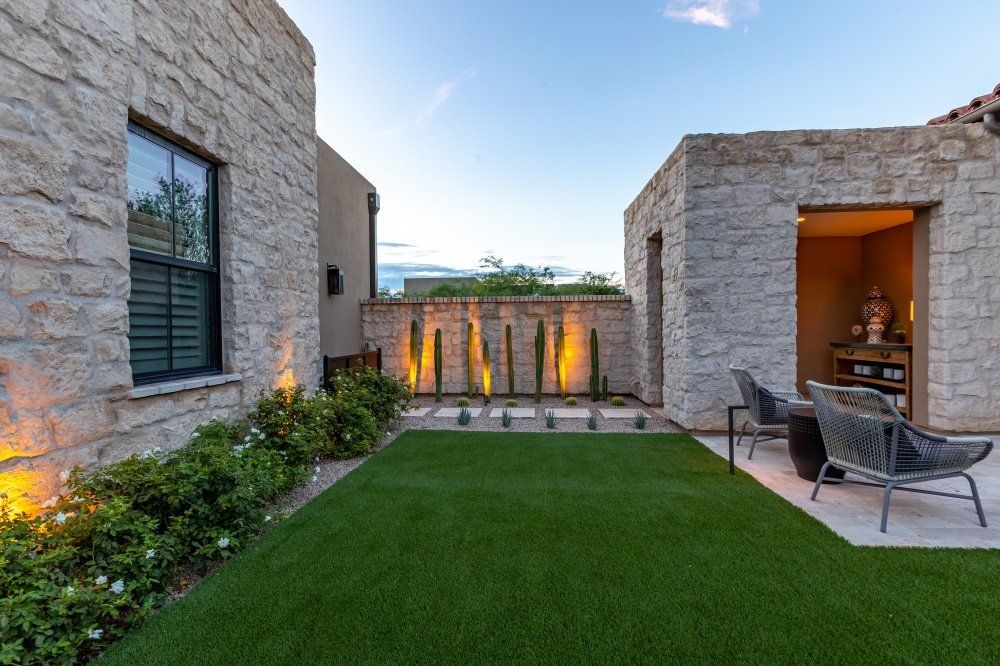 A stone house with a large lawn in front of it.