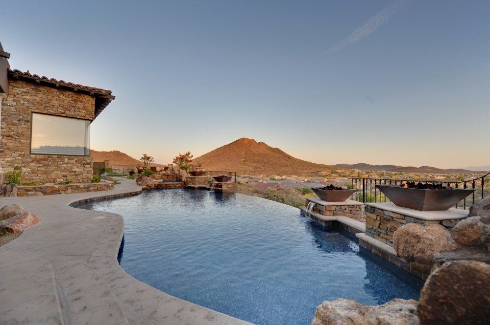A large swimming pool is surrounded by rocks and mountains.