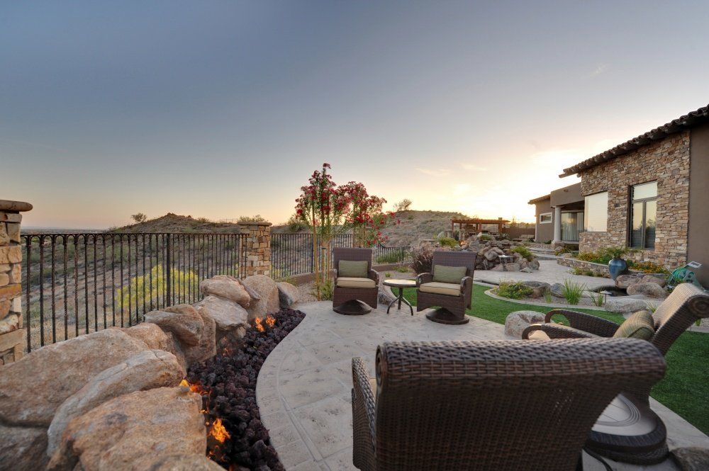 A patio with wicker furniture and a fire pit