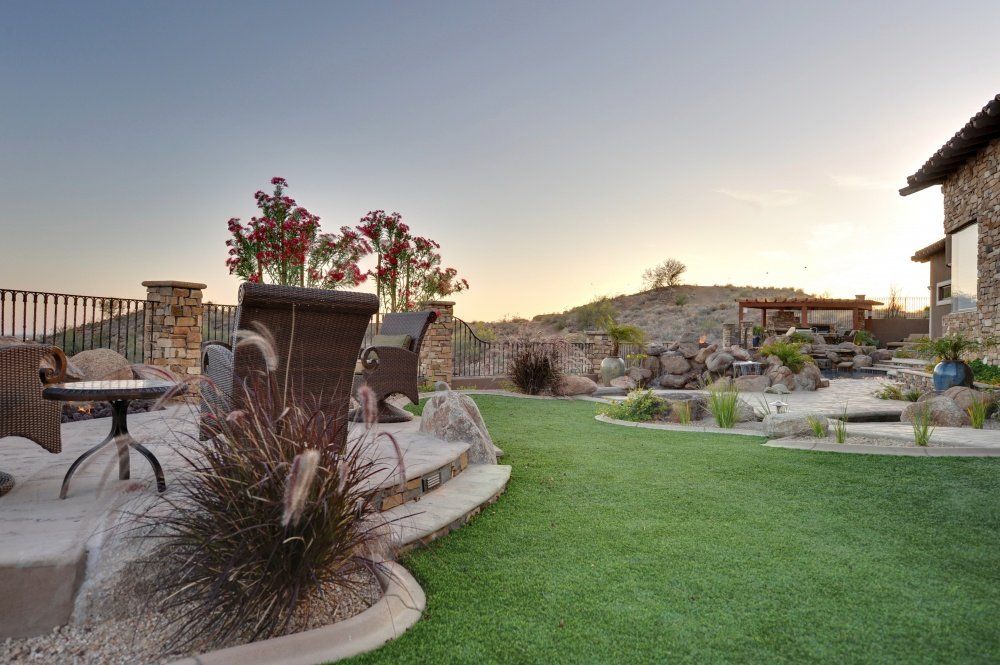 A backyard with a lush green lawn and a table and chairs.