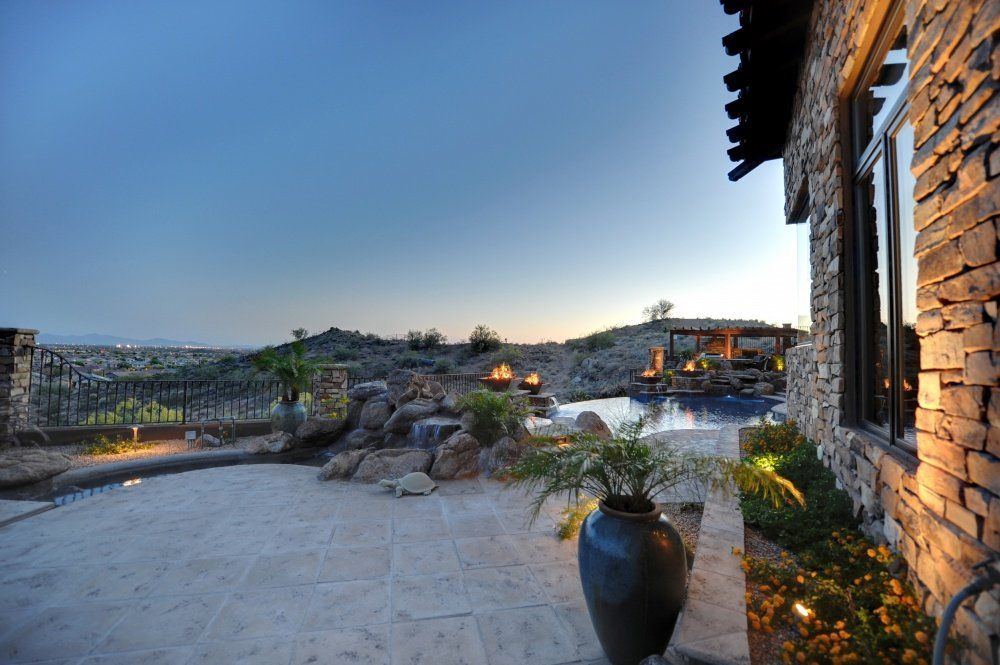 There is a large potted plant in front of a stone building.