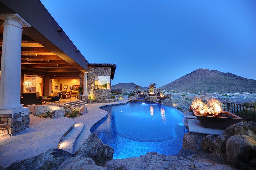 A house with a large swimming pool and a fire pit