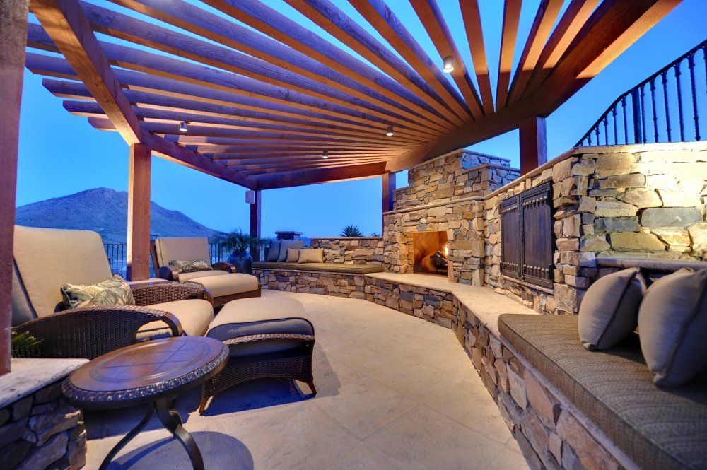 A patio area with a pergola and a fireplace