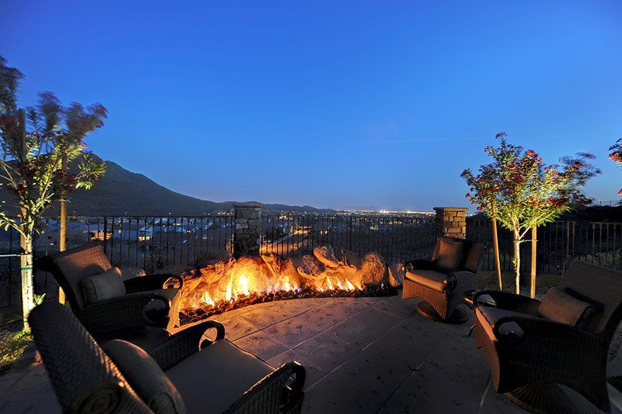 There is a fire pit on the patio with a view of the city.