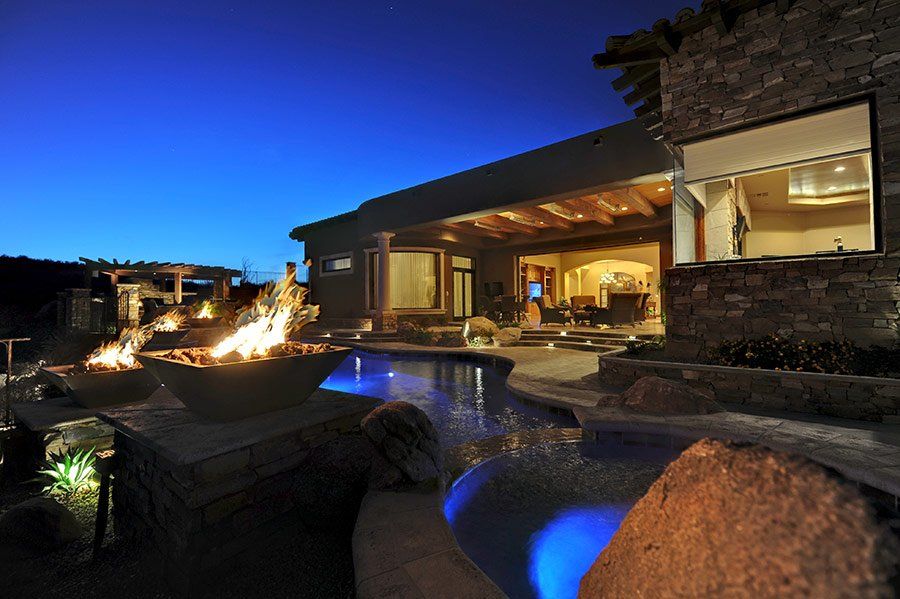 A house with a pool and a fire pit in front of it