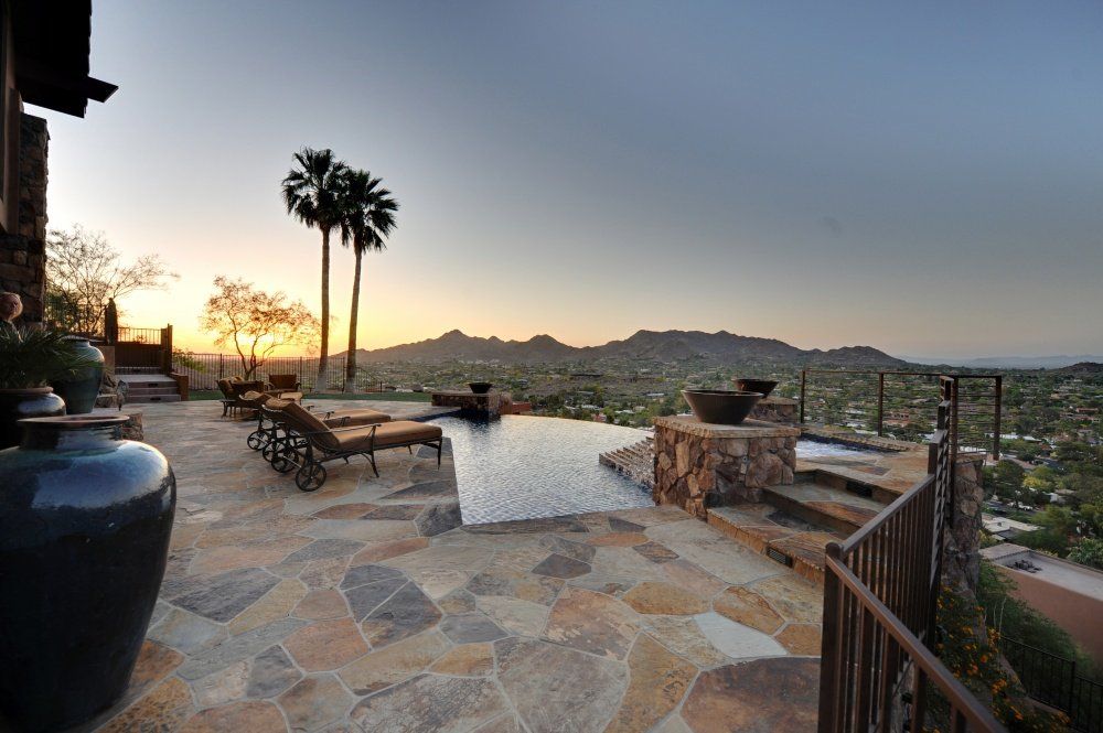 A large swimming pool with a view of mountains and palm trees