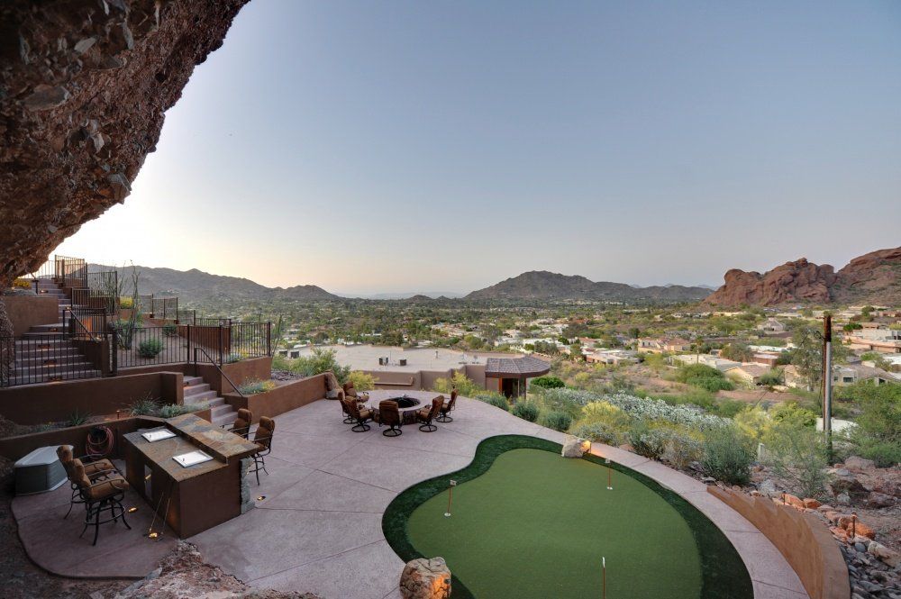 A patio with a putting green and a fire pit
