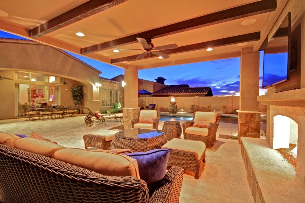 A patio with wicker furniture and a flat screen tv